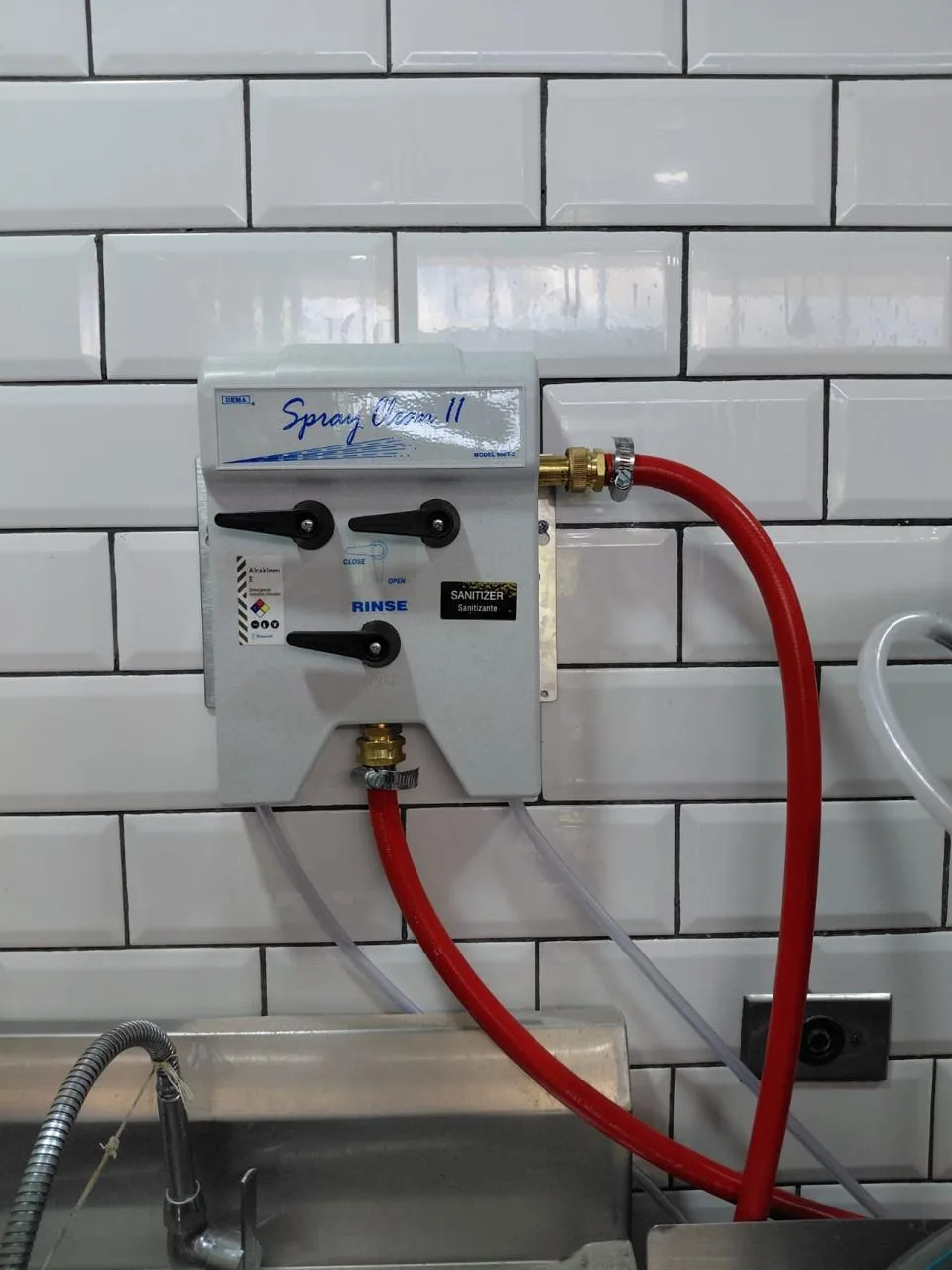 Estación de dosificación DEMA Spray Clean II instalada en una cocina industrial, con selección de detergente, sanitizante y enjuague.